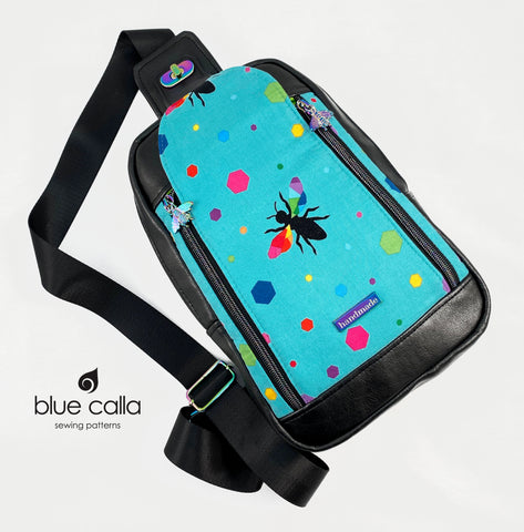 Speedwell backpack sling in Rainbow Hexagon bee in aqua with black faux leather